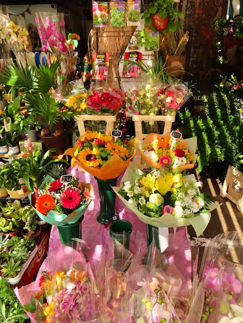 A vibrant display of fresh floral arrangements and bouquets in a florist shop, showcasing a variety of colorful flowers including sunflowers, gerbera daisies, and roses, wrapped in decorative paper an